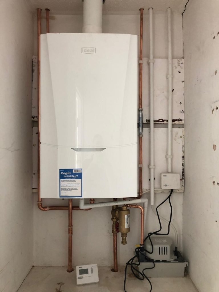 Ideal combi boiler installed in a cupboard with new copper pipework and condensate pump