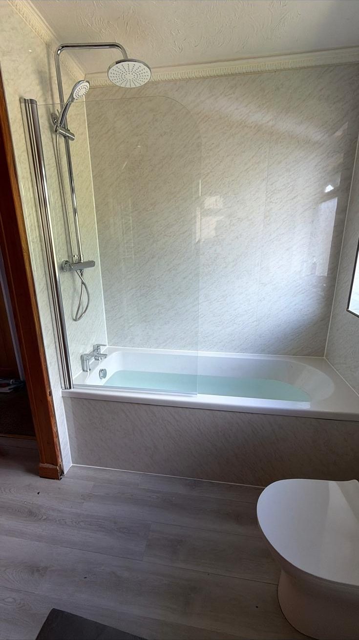 Bath with thermostatic rainfall shower and glass screen
